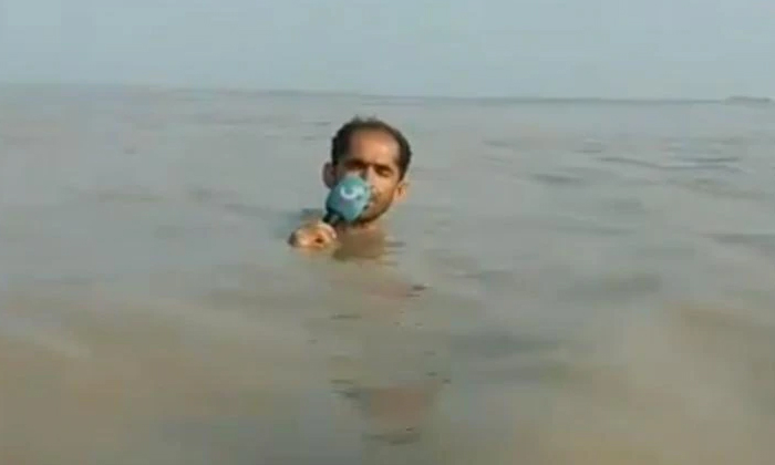 Reporter Stands In Neck Deep Water To Report Reporter Stands In Neck Deep Water To Report-TeluguStop.com