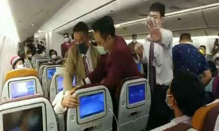 Woman Pinned Down Arfter Intentionally On Thai Air Lines In China 1-TeluguStop.com