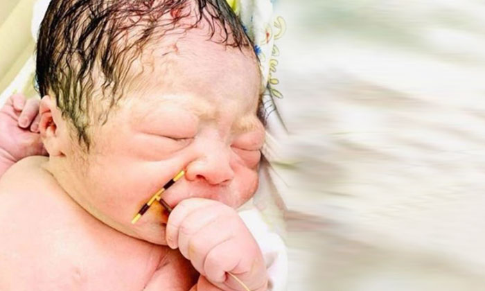  A Contraceptive Device In The Hand Of A Newborn Baby,contraceptive Coil,new Born-TeluguStop.com