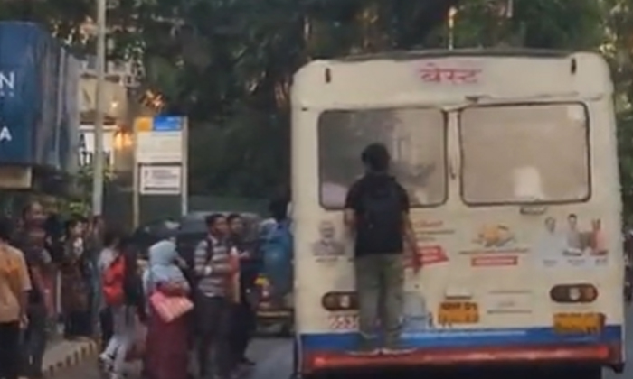  The Young Man Is Traveling By Hanging On The Back Of The Bus, Viral News, Latest-TeluguStop.com