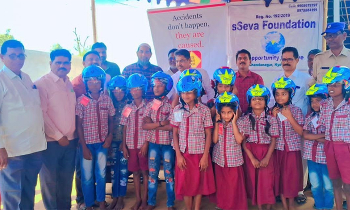  Distribution Of Helmets To Students And Parents Under The Auspices Of Sseva Foun-TeluguStop.com