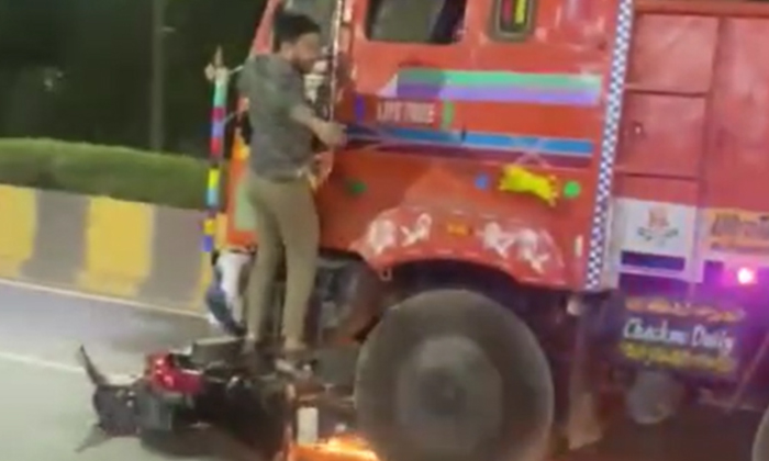  Rider Hangs From Truck His Bike Dragged On Road After Crash,lorry Accident, Vira-TeluguStop.com