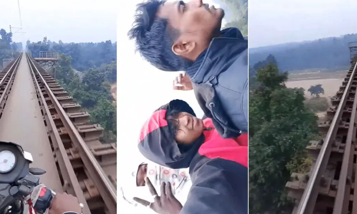  Biker Performs Dangerous Stunt For Reels Rides Triple Seat On Railway Bridge Vid-TeluguStop.com